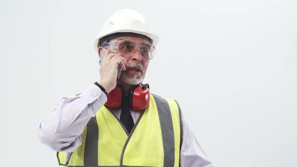 Adult Engineer in a Working Uniform Speaks on the Phone in the Studio on a White Background