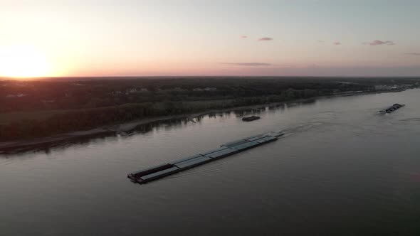 Aerial parallax around tugboat pushing barges up Mississippi River, St. Louis.