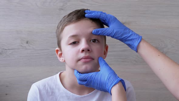 Pediatrician in Latex Nitrile Gloves Examines Eyeball Teeth Mouth of a Boy