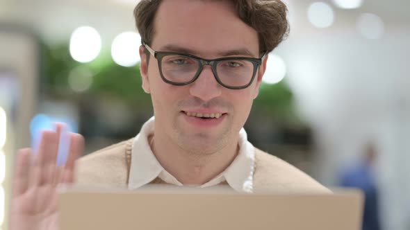 Close Up of Young Male Designer Making Video Call on Laptop