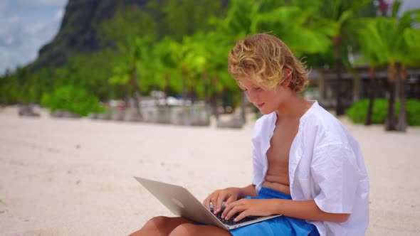 Man is Typing on the Keyboard on the Background of a Beautiful Beach