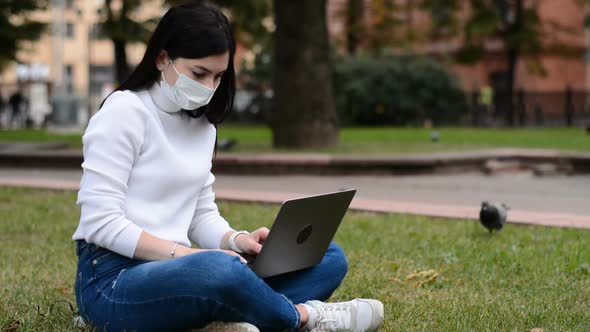 Caucasian Woman Wear Protective Face Mask and Work on Laptop Computer