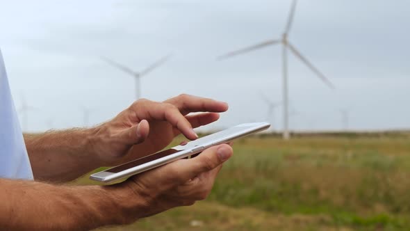 The Specialist Uses a Tablet To Control Wind Farms. Production of Environmentally Friendly