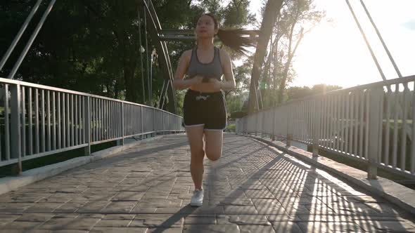 Young Asian Jogger Having a Morning Run Jogging Down the Track in Summer Park Healthy Way of Life