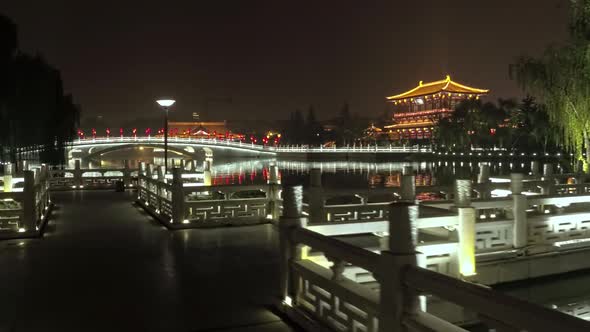 A Fabulous Chinese Pagoda with a Bridge Illuminated By Bright Lanterns on the Lake at Night