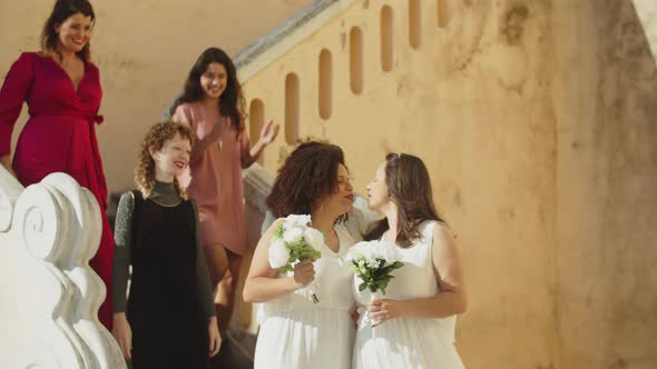 Happy Female Couple with Friends After Wedding Ceremony