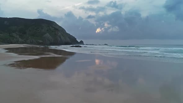 Flying Over Beach with Reflection Clouds and Sun