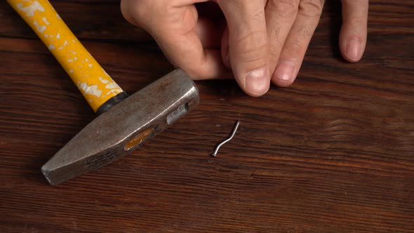 A Blackened Fingernail on the Finger of a Man Holding a Construction Hammer