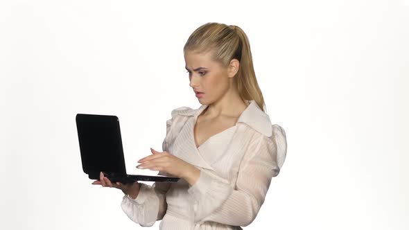 Young Angry Businesswoman Works on Notebook. White