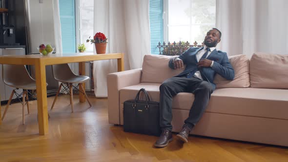 African Entrepreneur Relaxing on Couch Coming Home From Work