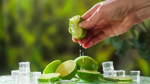 Hand Squeezing Lime on Nature Background