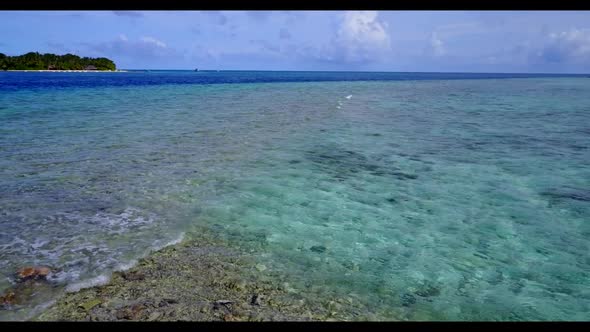 Aerial panorama of tranquil seashore beach lifestyle by blue lagoon and white sand background of a d