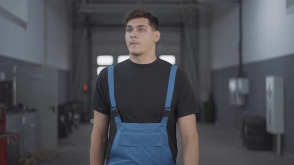 Confident Handsome Young Repairman Walking in Slow Motion in Auto Repair Shop