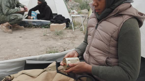 Homeless Girl with Tin of Food Sitting in Tent