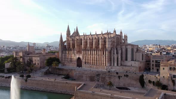 Aerial flying backwards of Cathedral of St. Mary of Palma on sunny day, Spain