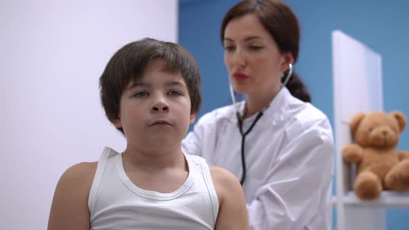 Portrait of Caucasian Boy Inhaling and Exhaling As Doctor Listening Auscultation with Stethoscope