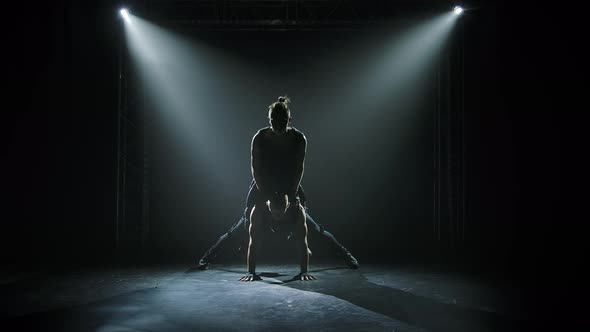 Two Gymnastic Acrobatic Men on Balance Pose. Silhouettes of Strong Athletic Men Performing Complex