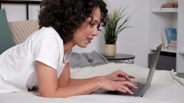 Smiling Hispanic Curly Woman Student Study Uses Laptop Distance Education