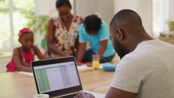 African american man using laptop while working from home