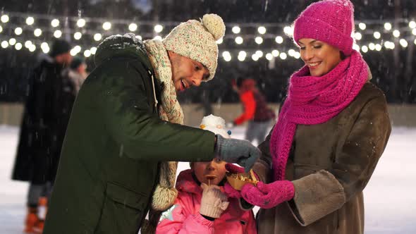 Happy Family Eating Pancakes on Skating Rink