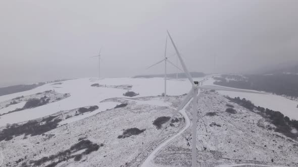 Aerial View of a Wind Farm in Winter Rotating Turbines on a Snowy Field in Ukraine