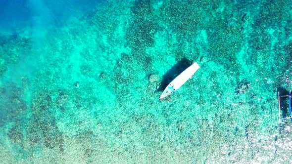 Touring boats floating over crystal emerald water of turquoise lagoon full of coral reefs and pebble