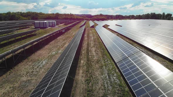 Aerial View of Solar Power Station. Panels Stand in a Row on Green Field. Summer