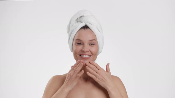 Close Up Portrait of Beautiful Happy Middle Aged Lady with Towel on Head Making Facebuilding Massage