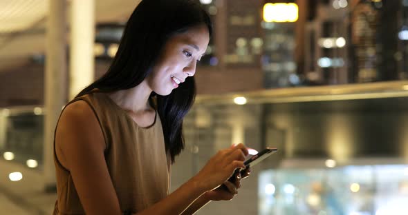 Woman using smart phone in Hong Kong at night 