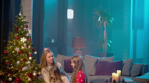 Little Sisters Decorating Christmas Tree with Mother at Home