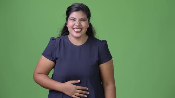 Young Overweight Beautiful Indian Businesswoman Against Green Background