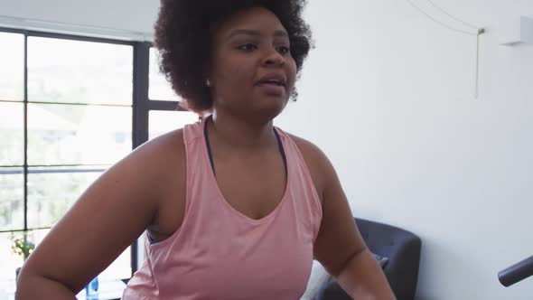 African american female plus size standing on exercise mat working out