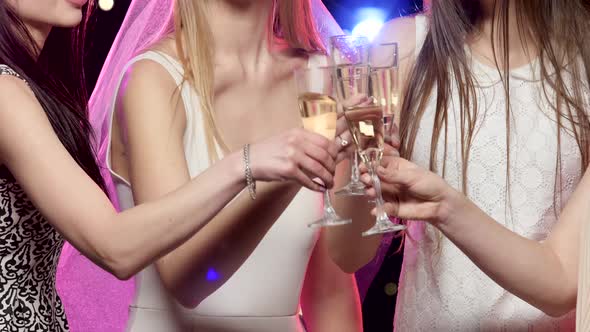 Girlfriends Clinking Glasses and Drinking Champagne at Bachelorette Party