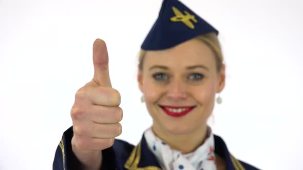 A Young Stewardess Smiles and Shows a Thumb Up To the Camera - Hand Closeup - White Screen Studio