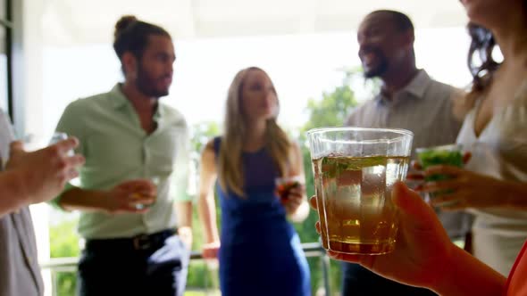 Group of friends interacting with each other while having drinks