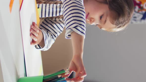 Vertical View of Adorable Kid Girl Drawing with Pencils at Home