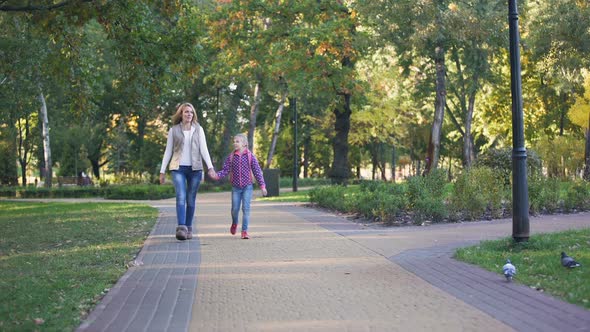 Excited Mother and Daughter Going Shopping Together, Holding Hands, Happiness