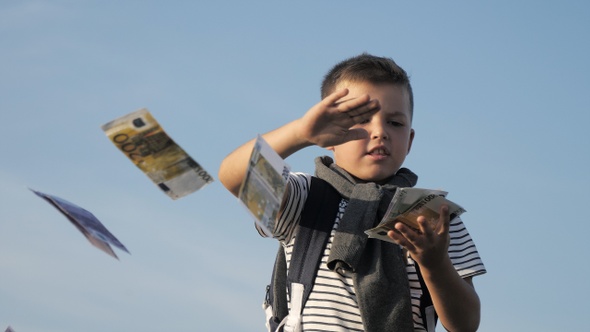 Boy throws money into the air.