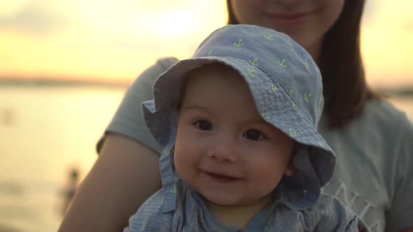 The Little Boy Smiles in His Mother's Arms