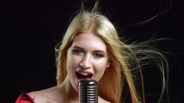 Singer Performs Songs in a Retro Microphone. Black Background. Close Up