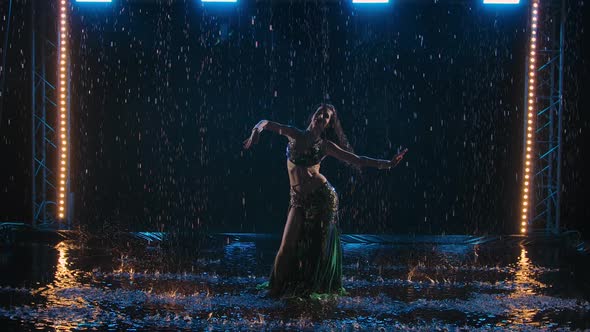 Silhouette of a Slender Long Haired Oriental Dancer Enjoying a Dance in the Rain