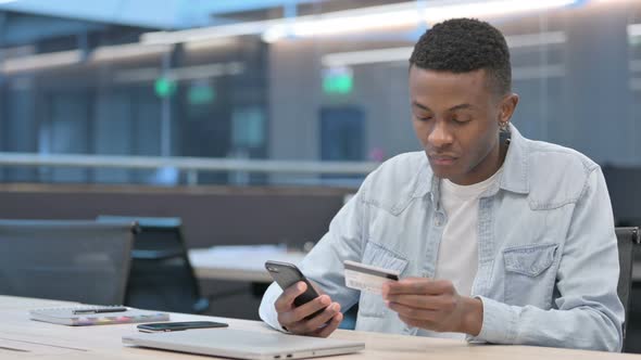 African Man making Online Payment on Smartphone