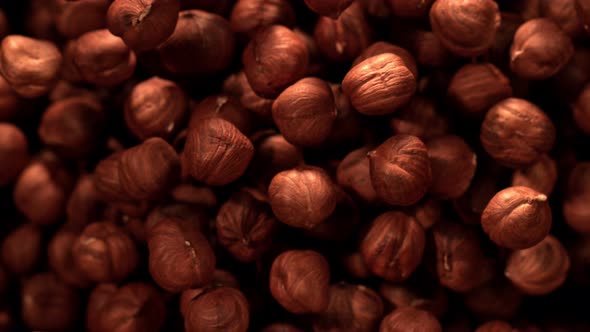 Super Slow Motion Shot of Hazelnuts Flies After Being Exploded Against Black Background, 1000Fps.