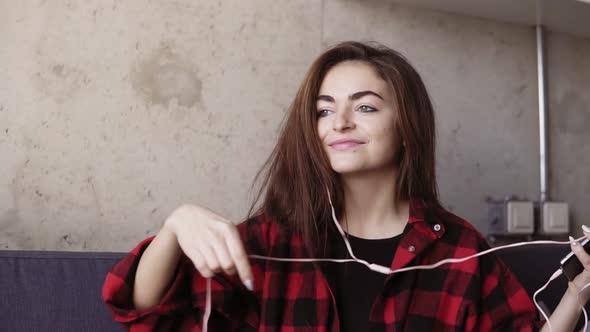 Sexy Beautiful Young Girl Puts Headphones in Her Ears and Starts Dancing to Some Music