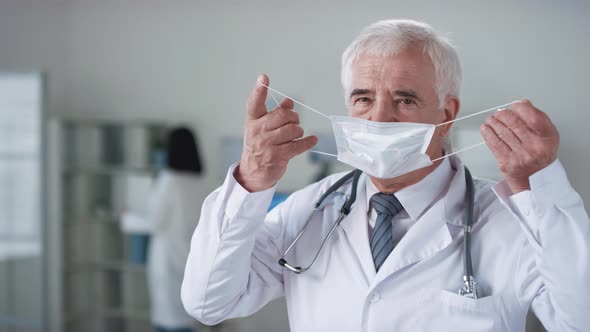 Mature Doctor Putting On Mask