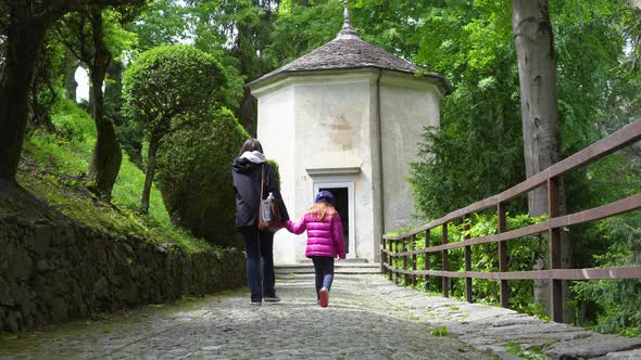 A mother and her little daughter carrying a teddy bear visiting the sacred mountain of Varallo chris