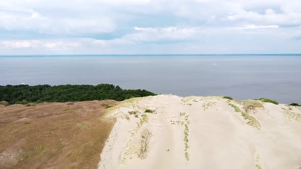 End of sandy dune with view to Curonian lagoon, drone descending view