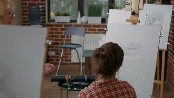 Young Woman Receiving Drawing Advice From Teacher in Art Class