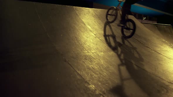 Sporty Man Riding Bmx Bicycle on Ramp at Skate Park