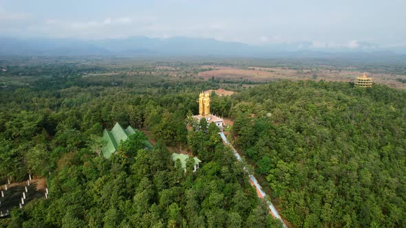 Aerial drone circling Golden Wat Doi Sapanyoo with a large staircase leading to four unique buddha s